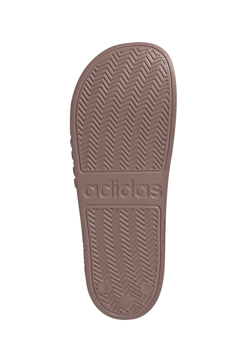 Adidas-Schuhsohle aus hellbraunem Gummi mit einem Fischgrätprofil und eingeprägtem Logo, abgerundeten Kanten und verstärkter Ferse.