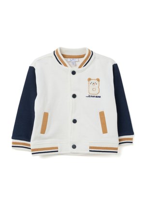 Giacca di cotone bianco con maniche blu navy, dettagli beige e ricamo di un orso sul petto. Presenta colletto, polsini e bottoni a pressione ribattuti.