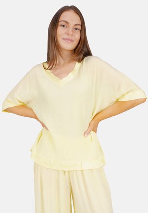 Haut en tissu froissé jaune avec un décolleté en V et des manches courtes, présentant un ourlet volé et des accents satinés. Convient pour un usage décontracté.