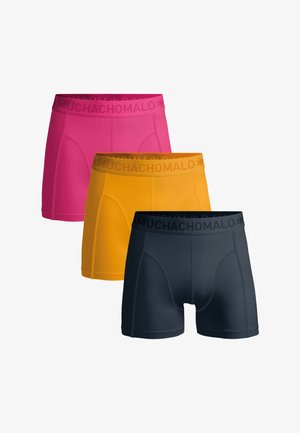 Drie paar boxershorts in roze, geel en marineblauw, met een zachte tailleband met het logo "MUCHACHO MALO", gemaakt van glad materiaal.