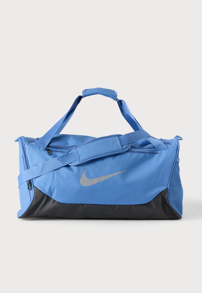 Μπλε και μαύρη τσάντα Nike με λουρί ώμου και πάνω χειρολαβές, εμπρόσθια τσέπη με φερμουάρ και ορατό λογότυπο σε μονόχρωμο φόντο.