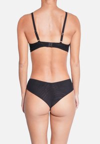 Soutien-gorge noir bordé de dentelle avec bretelles ajustables, assorti à une culotte taille haute. Tissu lisse et extensible avec un léger éclat.