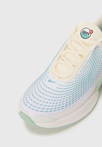 Leichter Sneaker mit einem atmungsaktiven Mesh-Obermaterial, sanftem Creme- und Blauton, strukturiertem Muster und mintgrünen Akzenten an der Sohle.