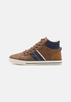 Des sneakers montantes marron présentent un dessus en cuir texturé avec des rayures navy et un collier rembourré, le tout terminé par une semelle en caoutchouc blanche.