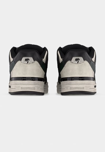 Ζευγάρι αθλητικών παπουτσιών σε μαύρο, άσπρο και γκρι χρώμα, που φαίνεται από πίσω, με λογότυπο φοίνικα στη φτέρνα και μαύρη ρίγα με τη μάρκα πάνω από την σόλα.