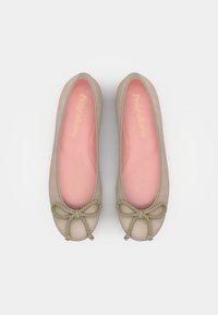Beige ballerinas med en mjuk mockayta, rosa innersulor och en grön snoddrosett vid tålinjen. Klassisk rund form.