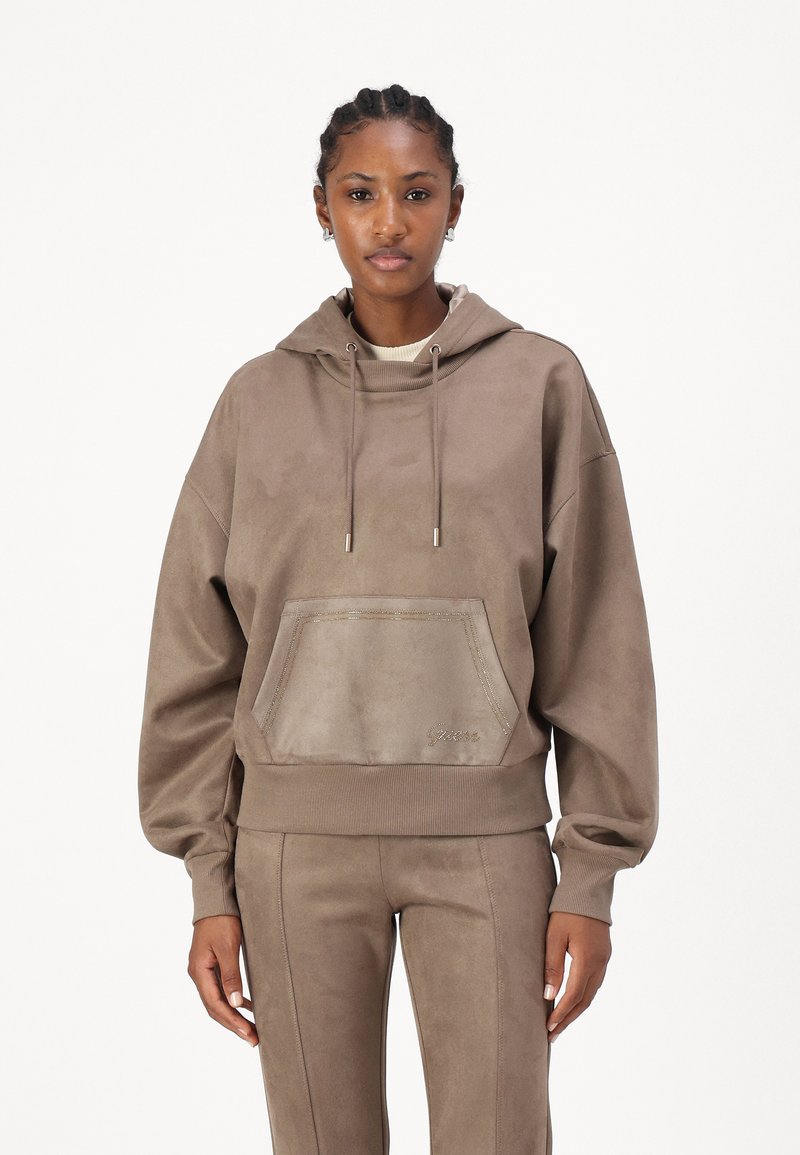 Sudadera con capucha de gran tamaño en color beige, con un bolsillo frontal, dobladillo acanalado y cordón ajustable. Está hecha de un tejido texturizado con un ligero brillo.