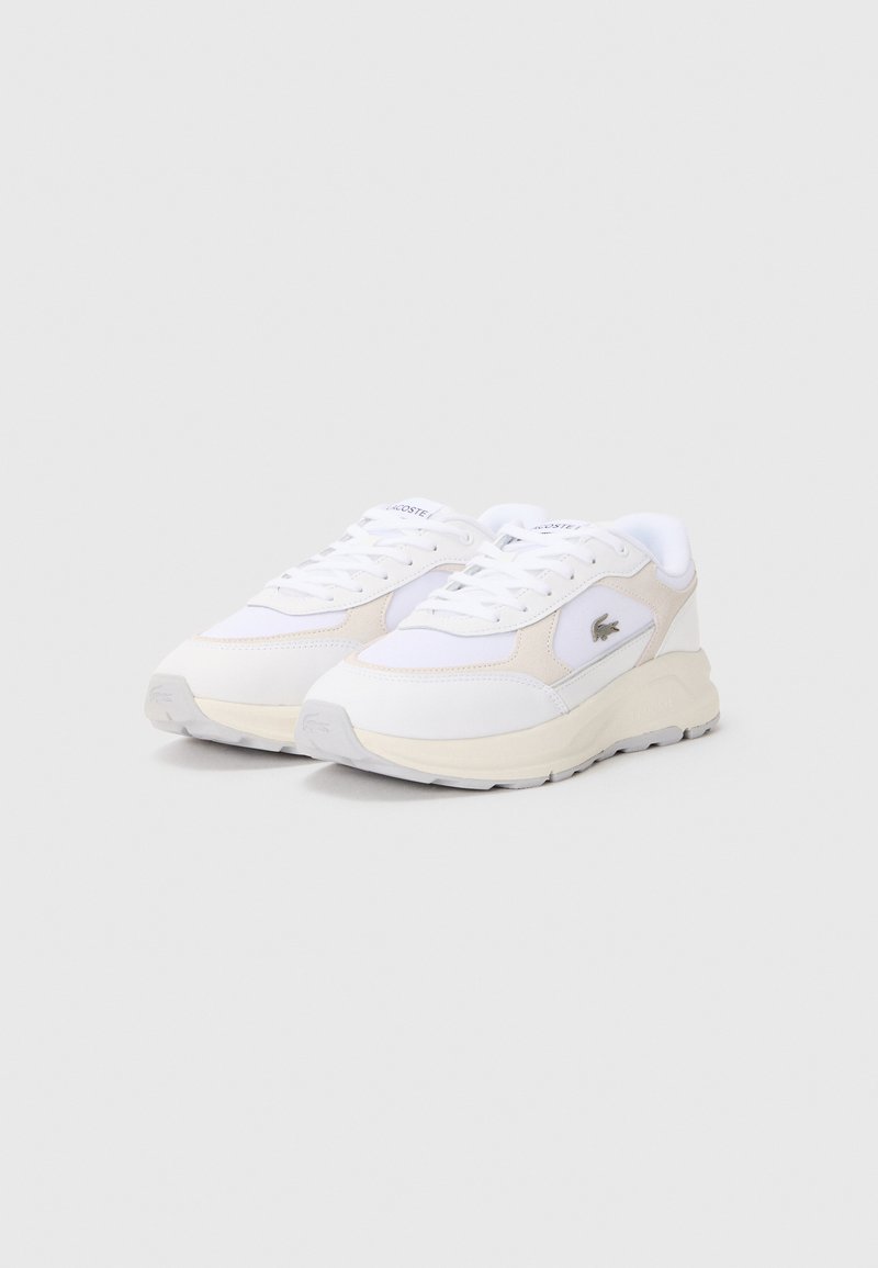 Sneaker atletiche bianche con accenti beige, materiali in rete e pelle, punta rotonda, suola in gomma testurizzata e chiusura con lacci.