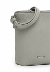 Borsa a mano in pelle grigia con finitura testurizzata, dotata di manico rotondo e un accento in logo argentato. Design quadrato compatto.