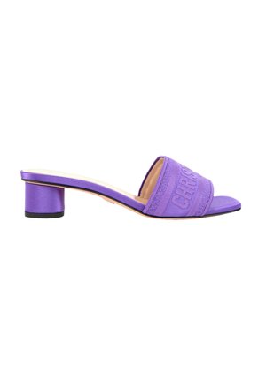 Mule violette à bout ouvert avec talon bloc et large bride en tissu embossée de texte sur le dessus du pied.