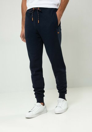 Marine joggerbroeken met elastische boorden, een trekkoord in de taille en oranje accenten, zijzakken, gemaakt van een zachte katoenen mix.