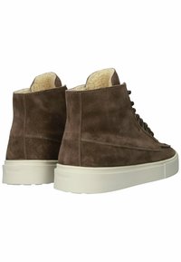 Bruine suède hoge sneakers met crèmekleurige nepbontvoering en een witte rubberen zool. Voorzien van veters en subtiele zijnaaddetails.