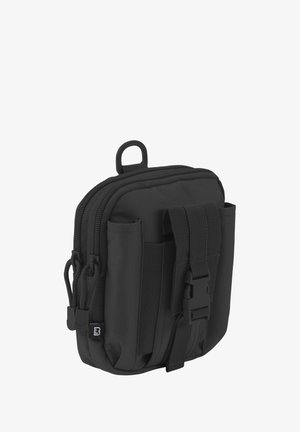 Kompaktne mustast kangast kott kahekordse tõmblukuga, eesmine klambri pandlaga, külgsilmustega ja ülemise kinnitusrõngaga.