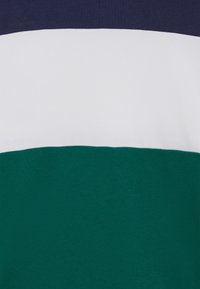 Tessuto a righe con bande orizzontali in blu navy, bianco e verde scuro; texture morbida; distribuzione uniforme del colore su tutta la superficie.