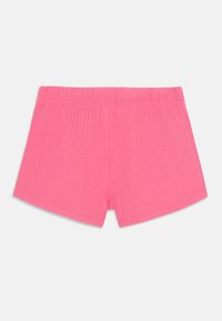 Rosa ribbede shorts med elastisk midje. Stoffet er strikkbart og mykt, med et enkelt, sømløst design uten ekstra detaljer.