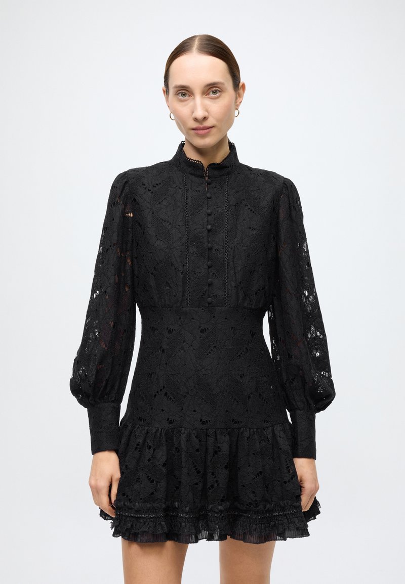 Black lace dress with a high collar, button front, and long puff sleeves. Features a flared hem with ruffled accents and intricate floral patterns.