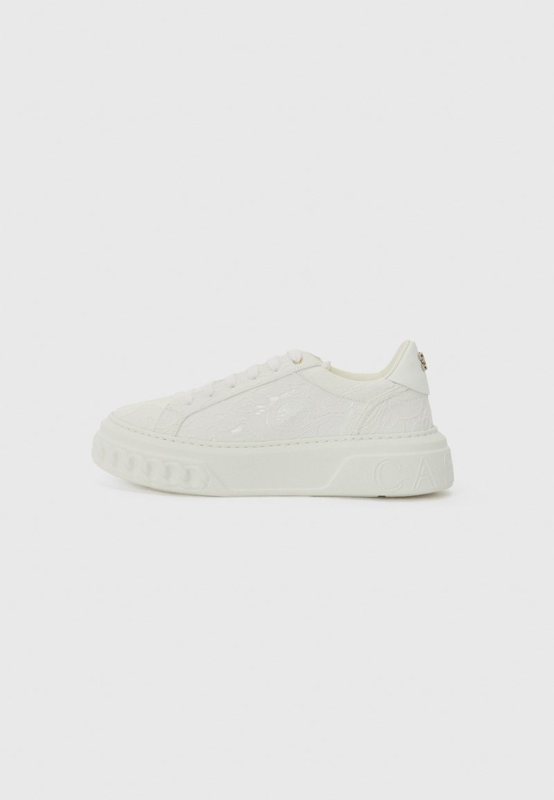 Vitt sneakers med överdel i texturläder, rund tå och tjock sula. Har subtil logga på hälen och snörning framtill med släta snören.