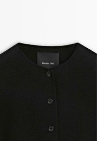 Black wool jacket with a round neckline, featuring five black buttons and a label reading "Massimo Dutti." Soft texture and minimalistic design.