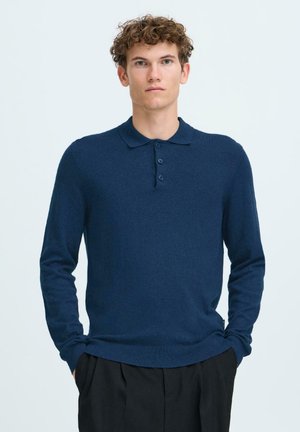 Marine langermet polo genser laget av mykt strikket stoff, med en tre-knapps placket og ribbestrikkede mansjetter og kant.