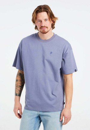 T-shirt di cotone viola con colletto rotondo e maniche corte. Presenta un piccolo logo sul petto e un'etichetta laterale.