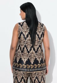 Top senza maniche con una base nera decorata da intricati motivi damascati oro. Tessuto liscio con una vestibilità comoda, abbinato a pantaloni coordinati.