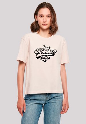 Helle rosa Baumwoll-T-Shirt mit kurzen Ärmeln und lockerer Passform, das ein schwarzes Grafikdesign zeigt mit der Aufschrift "Bad Moms Club."