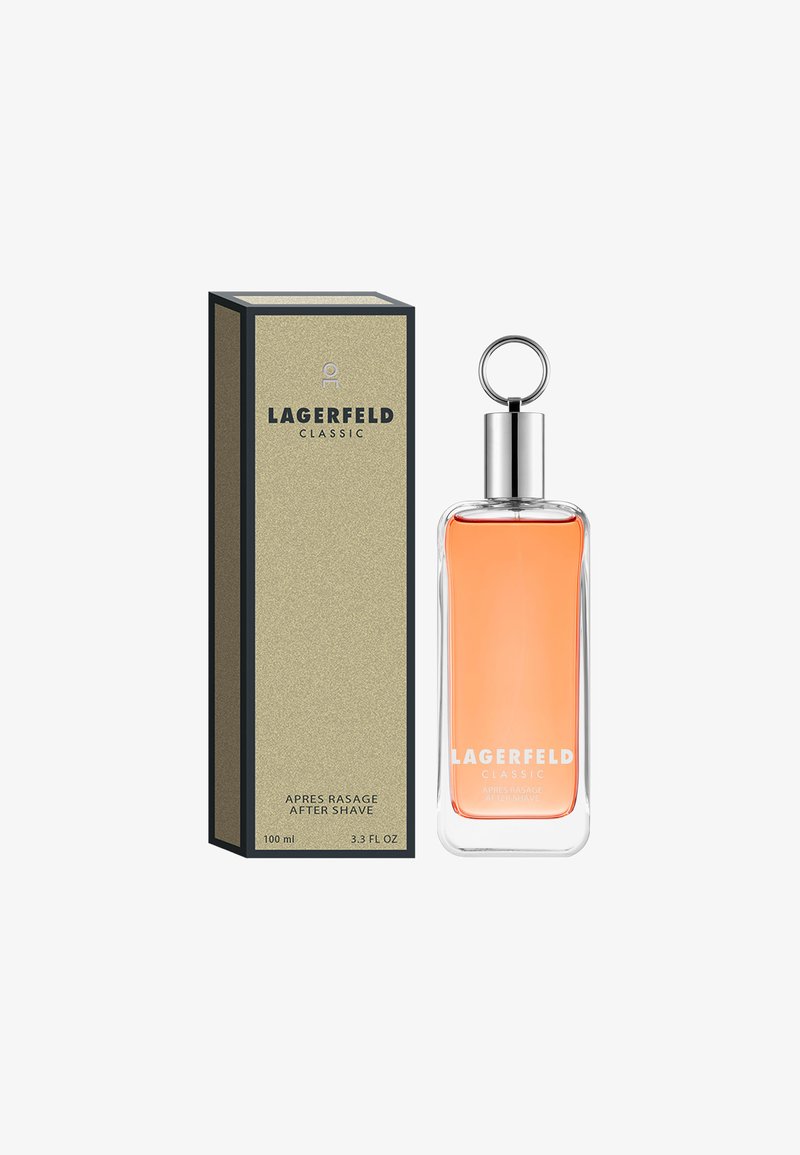 LAGERFELD Klassinen parranajovesi, 100 ml, sisältää kirkkaan lasipullon, jossa on hopeinen korkki ja rengas, sisältäen vaalean oranssia nestettä. Pakkaus on kultainen.