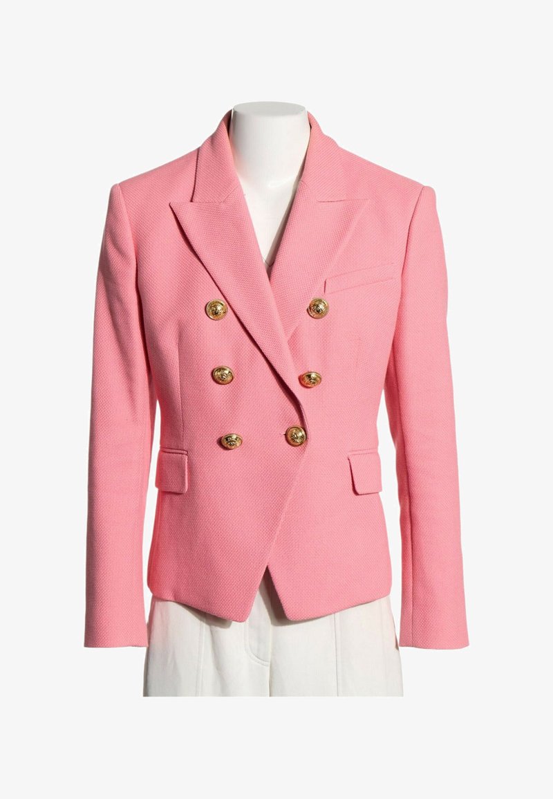 Blazer rose texturé à double boutonnage avec boutons dorés, revers crantés et poches à rabats sur un buste de mannequin blanc.