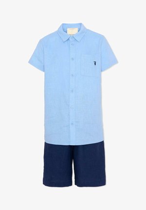 Chemise bleu clair à manches courtes avec boutons, col et poche poitrine, associée à un short bleu foncé arrivant aux genoux.