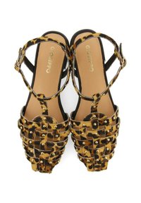 Sandalia de estampado de leopardo con diseño trenzado, tiras negras, tachuelas doradas y punta abierta. Presenta una suela plana y una correa de tobillo ajustable.