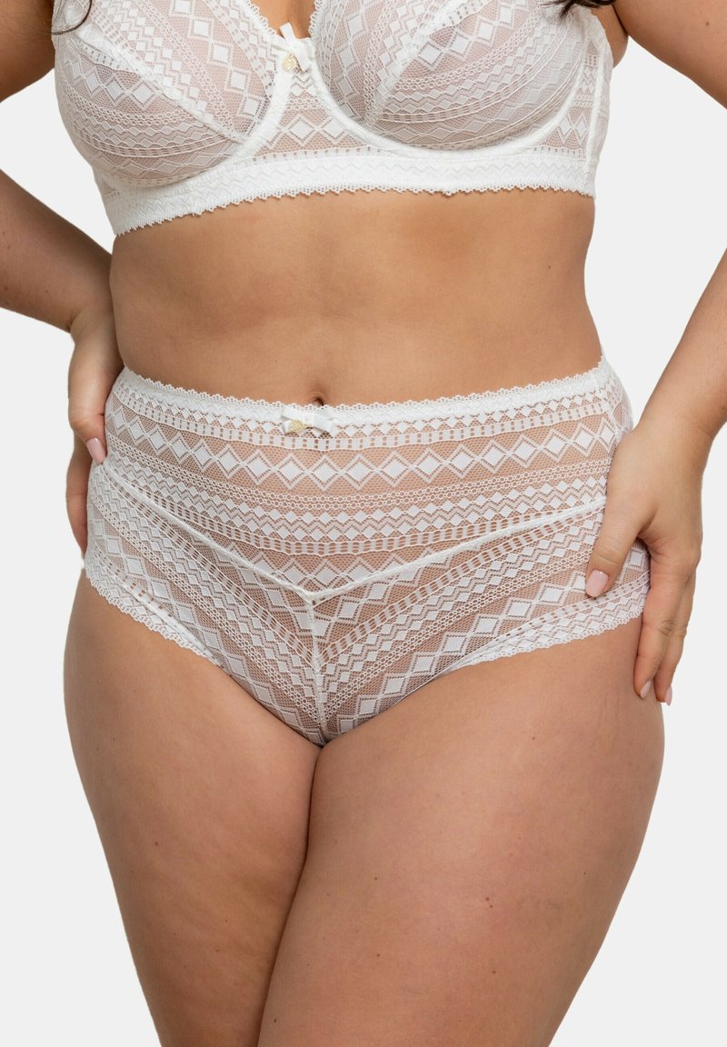 Soutien-gorge en dentelle blanche et culotte taille haute avec des motifs géométriques, des bords festonnés et un détail en satin en forme de nœud à la taille.