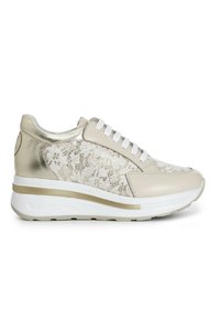 Sneaker beige con lacci, con un accento metallico dorato, sovrapposizione di pizzo testurizzato e suola bianca con una striscia dorata.