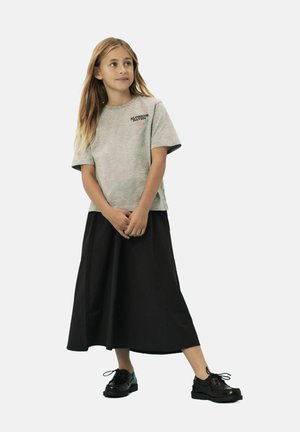 T-shirt en coton gris avec l'imprimé "BLOSSOM HAVEN", associé à une jupe noire évasée et des chaussures noires à lacets, sur fond blanc.