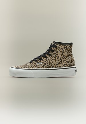 Baskets montantes avec imprimé léopard beige et noir, lacets noirs, semelle en caoutchouc blanche et logo Vans sur le côté et le talon.
