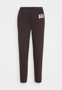Pantalones de chándal negros de algodón con cintura ajustable y puños acanalados, que presentan un logo rosa de "GAP" en el muslo izquierdo.