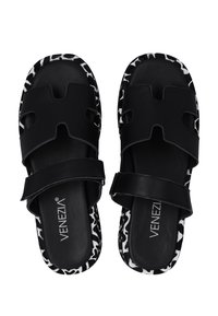 Černé sandály s výřezovým designem, s texturovaným černým páskem a potištěnou černobílou vzorovanou podrážkou. Název značky je viditelný uvnitř.