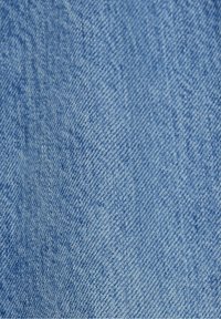 Tela de mezclilla azul claro con una textura suave, que presenta un patrón de sarga y sutiles variaciones de color en toda su superficie.