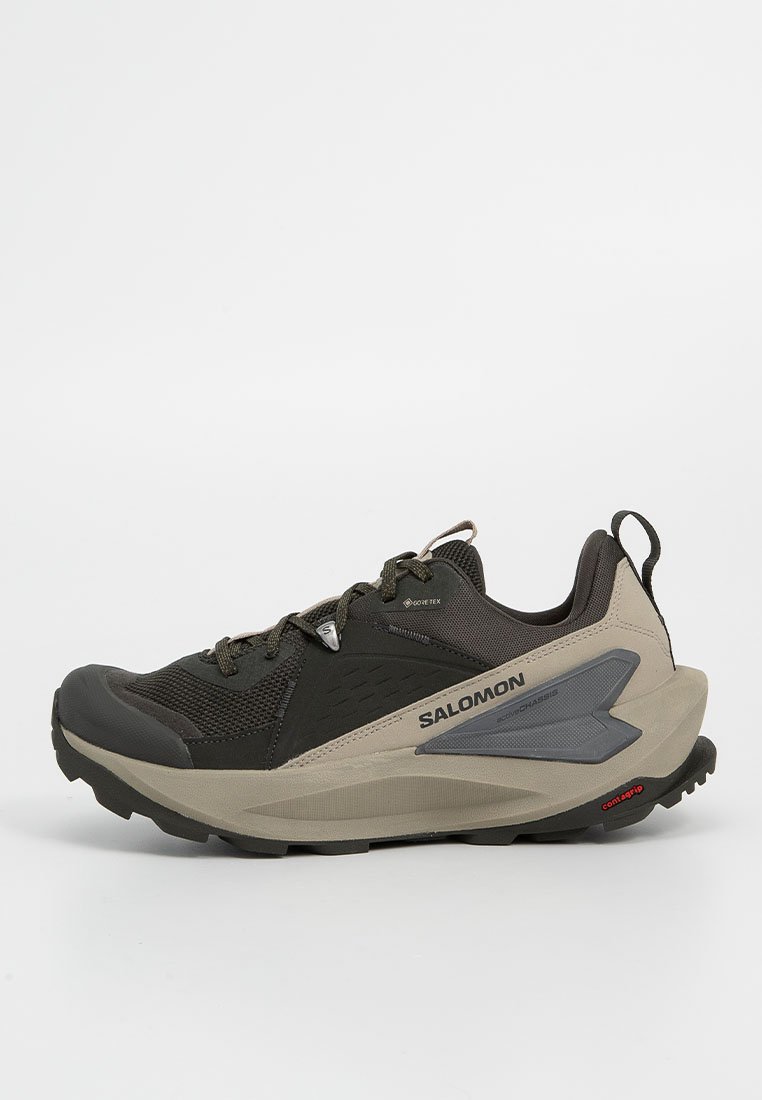 Zapatos de trail Salomon con una parte superior de color gris oscuro con detalles de malla y goma. La suela es resistente, con tacos para tracción. Marca Gore-Tex visible.