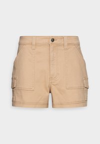 Beige bavlněné cargo šortky s předními kapsami na klopu, poutky na opasek a knoflíkovým zapínáním, zobrazené na jednobarevném světlém šedém pozadí.