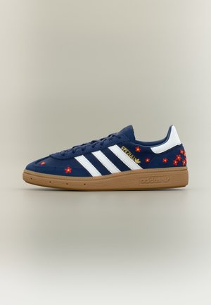 Navyblaue Adidas-Sneaker mit weißen Streifen, Gummisohle, weißem Fersenlaschen, roter und gelber Blumenstickerei und "Spezial" Text in Gold.