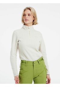 Pullover in pile color avorio con mezza zip, colletto alto e tessuto texturizzato. Abbinato a pantaloni verde brillante con passanti per cintura e tasche.