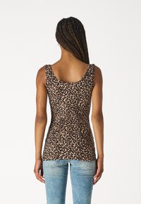 Leopard print tank top with a fitted silhouette, lightweight fabric, wide straps, and a scoop neckline. Paired with light blue jeans.