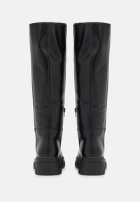 Black leather knee-high boots with a smooth texture, side zippers, and thick rubber soles. Features seam detailing along the shafts.