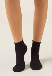 Černé kotníkové ponožky vyrobené z měkkého, pružného materiálu s žebrovaným lemem a hladkou texturou. Bez vzorů nebo ozdob.