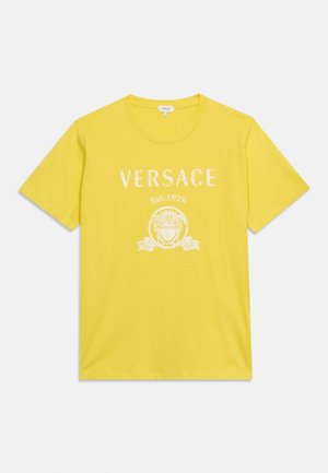 T-shirt jaune à manches courtes avec texte blanc "VERSACE Est. 1978" et logo Méduse imprimés sur le devant.