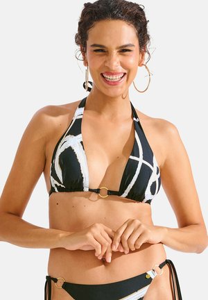 Zwart-witte bikini met een driekhoekige haltertop, voorzien van abstracte penseelstrekenpatronen en gouden accenthardware in het midden en aan de zijkanten.