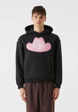 Black hoodie with a front pocket featuring a large pink cowboy hat graphic and white text, made from soft fabric with ribbed cuffs.