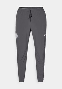 Nike löparbyxor, mörkgrå, lätt tyg, avsmalnande design, elastisk midja med dragsko, med logovtryck och fickor.