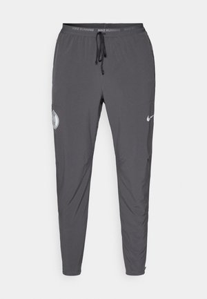 Nike running pants, dark gray, lightweight fabric, tapered design, elastic waistband with drawstring, featuring logo accents and pockets.