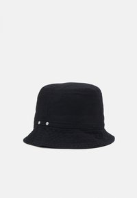 Chapeau seau noir en tissu texturé. Doté d'une couronne arrondie, d'un large bord, et de deux boutons d'accent en métal argenté sur le côté.
